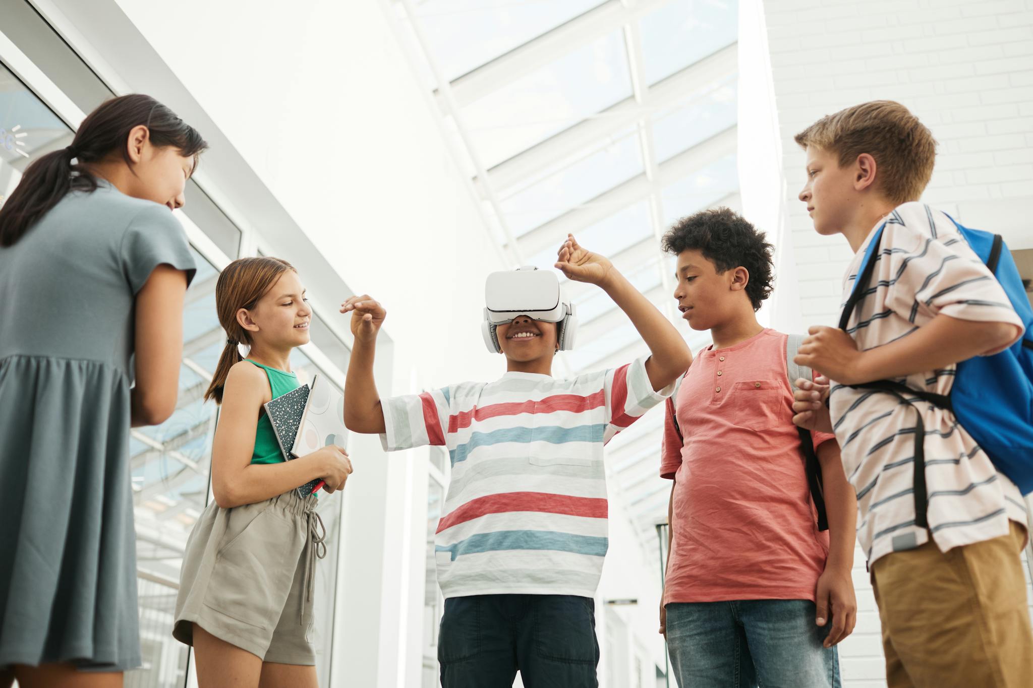 A group of diverse children immersed in virtual reality technology indoors.